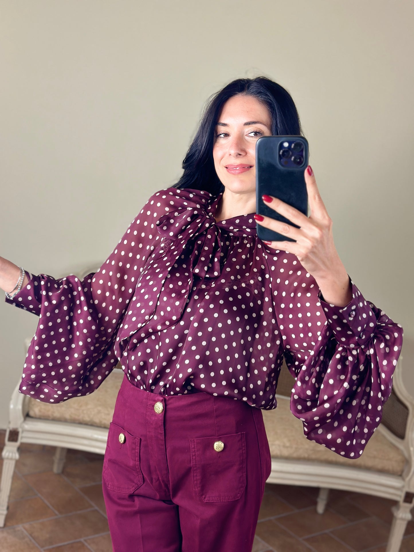 Tensione in blusa a pois con fiocco bordeaux