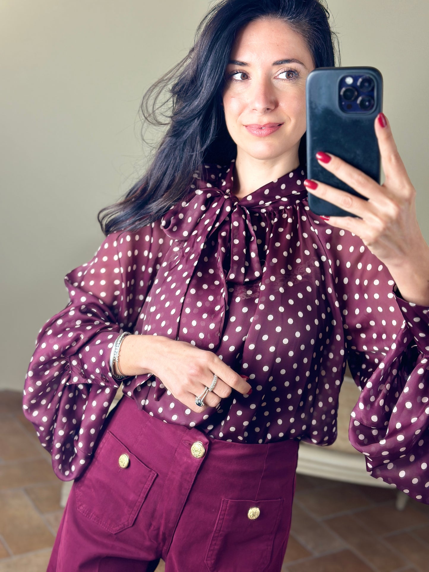 Tensione in blusa a pois con fiocco bordeaux