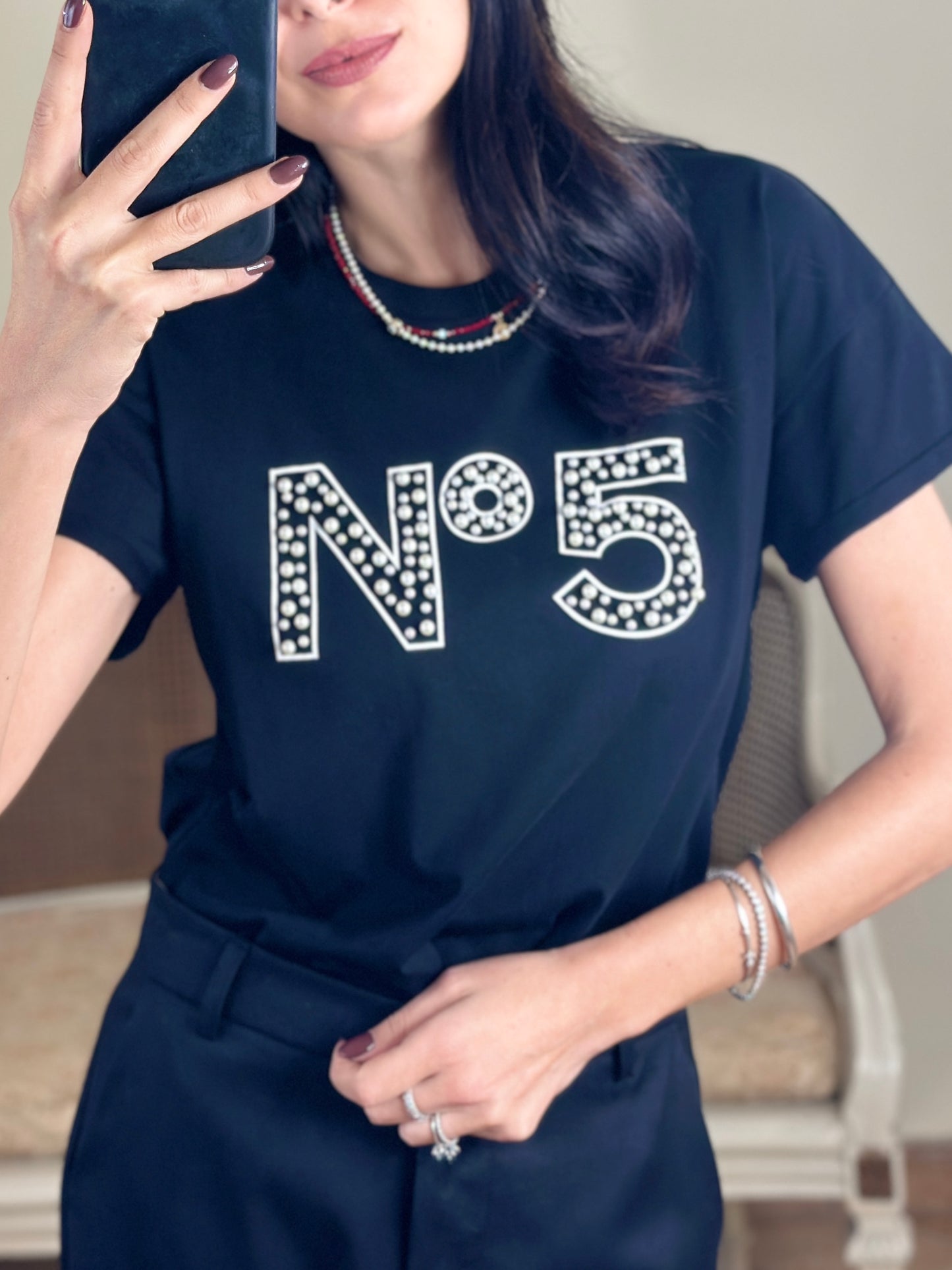 Tensione in T-shirt nera con perle e scritta “N.5”