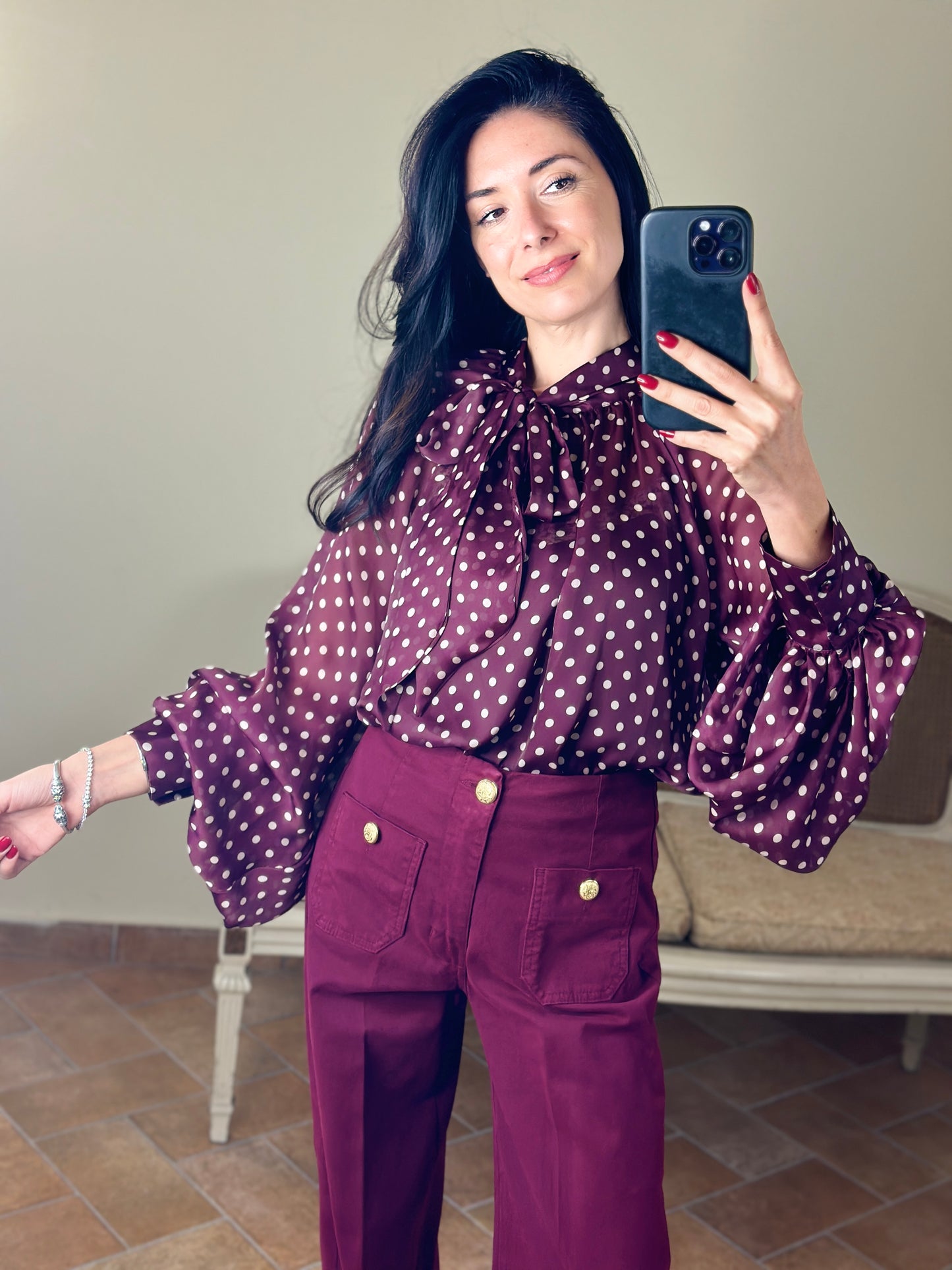 Tensione in blusa a pois con fiocco bordeaux