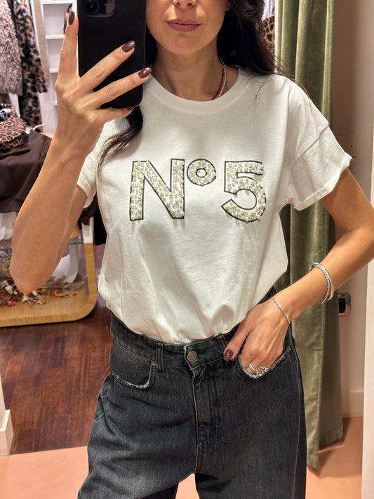 Tensione in t-shirt bianca con perle e scritta “N.5”