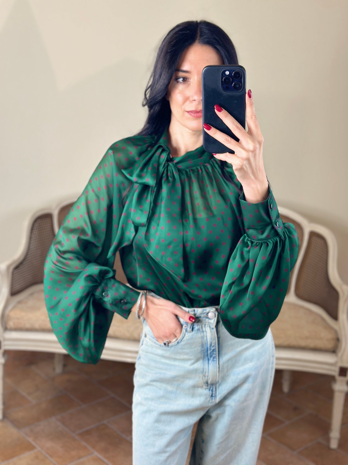 Tensione in blusa a pois con fiocco verde